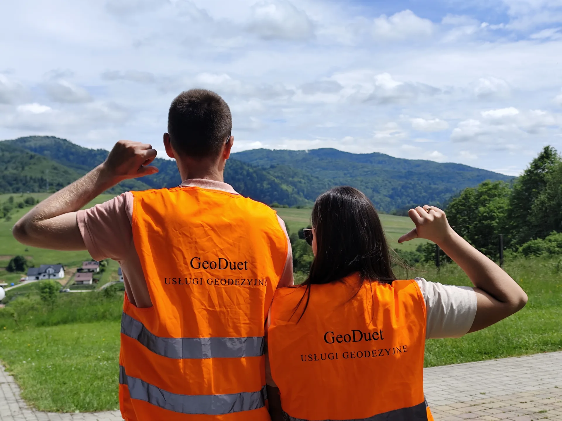 Dwóch pracowników GeoDuet w kamizelkach odblaskowych podczas pracy w terenie