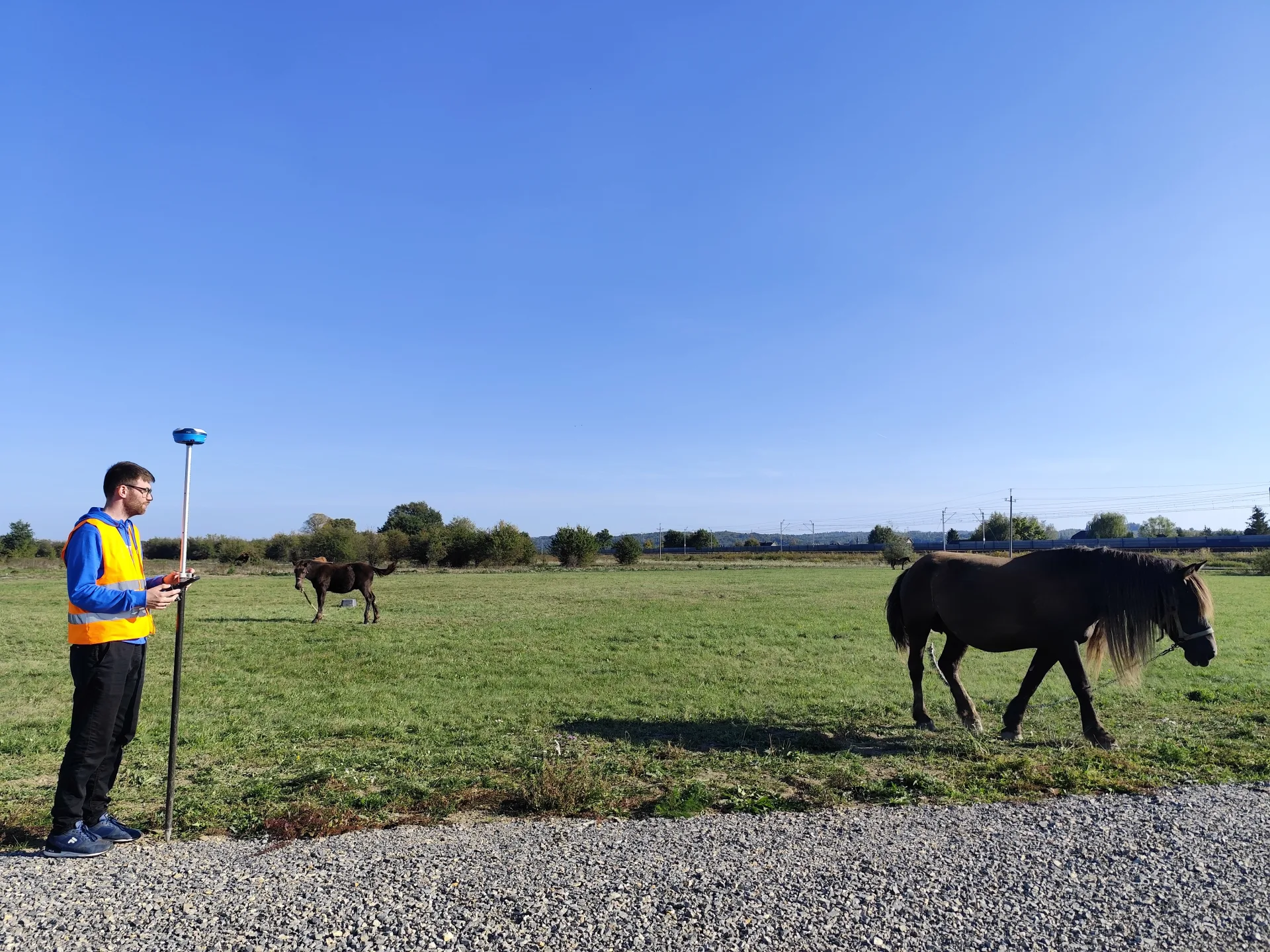 Geodeta GeoDuet z odbiornikiem GNSS podczas pracy w terenie